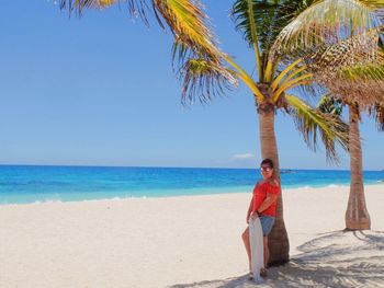 Full length of palm tree on beach against sky