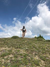 Low angle view of man standing on field against sky