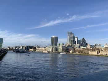 Sea by buildings against sky in city