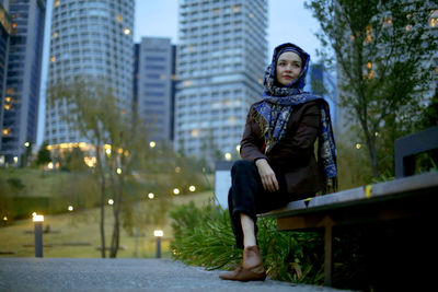 Portrait of young woman looking at city