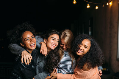 Happy friends smiling at night