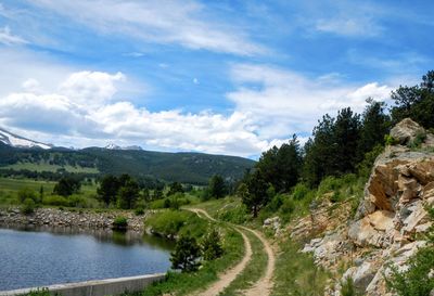 Scenic view of river amidst trees against sky