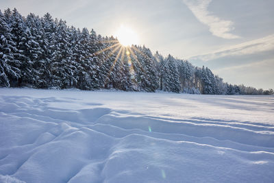 Snow covered landscape against sky