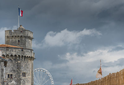 Low angle view of building against cloudy sky