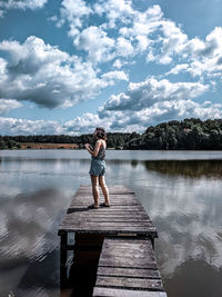 Woman standing on pier by lake