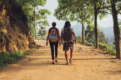 Rear view of men walking on footpath