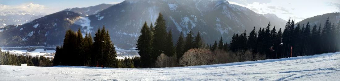 Panoramic view of snow covered mountains against sky