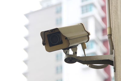 Low angle view of security camera against building
