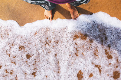 Low section of woman standing at beach