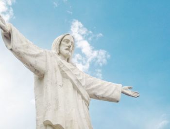 Low angle view of jesus statue against sky