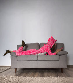 Portrait of woman sitting on sofa against white background