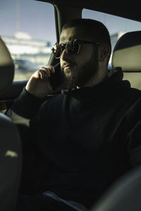 Man talking on mobile phone while traveling in car