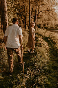 Rear view of woman walking on field