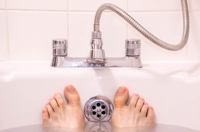 Midsection of woman in bathroom at home