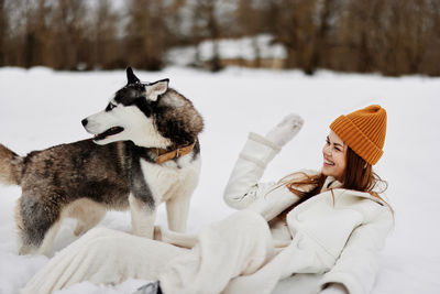 Portrait of man with dogs on snow covered field