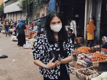 Woman standing by street market in city