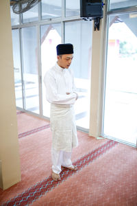 Young man praying in room