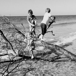 Friends on beach against clear sky