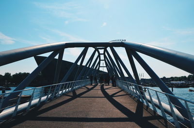 Surface level of footbridge against blue sky