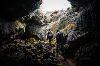 Rear view of people walking in cave