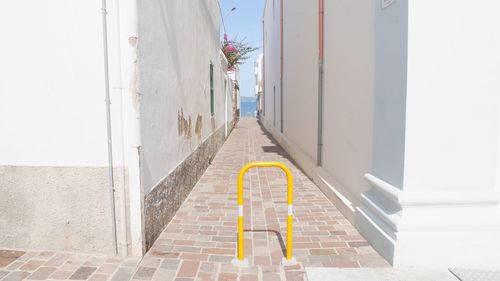 Footpath amidst buildings against clear sky