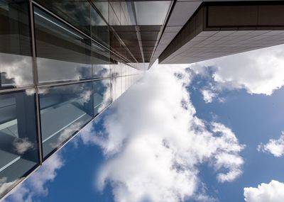 Low angle view of modern building against cloudy sky