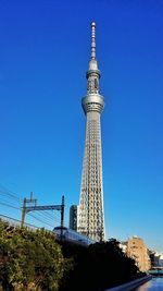 Low angle view of communications tower in city