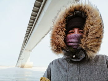 Portrait of woman wearing hat against sky during winter