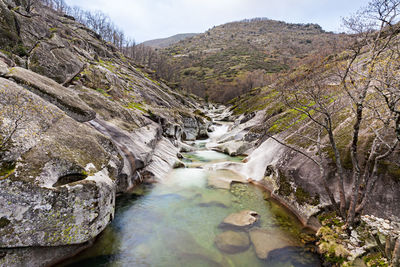 River flowing amidst mountains against sky