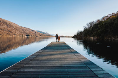 Mother and daughter on a pier on lake mergozzo