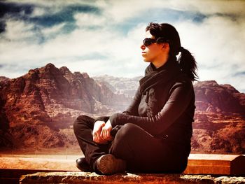 Portrait of young woman sitting on mountain