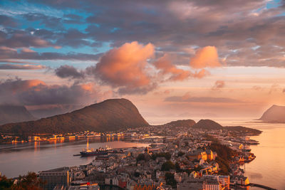 City by sea against sky during sunset