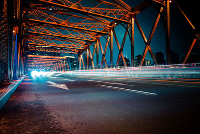 Light trails on bridge in city at night