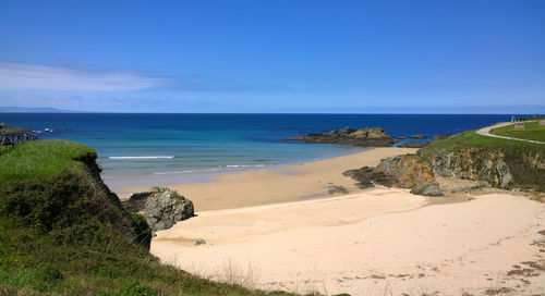 Scenic view of beach against clear blue sky