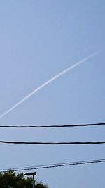 Low angle view of vapor trail against blue sky