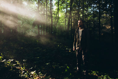 Man with beards standing in forest