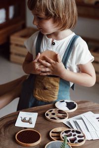 High angle view of boy playing with cookies on table