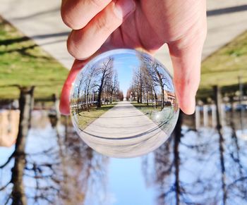 Close-up of hand holding crystal ball with reflection