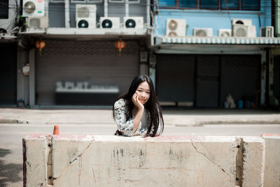 Portrait of smiling young woman in city