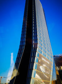 Low angle view of modern building against blue sky