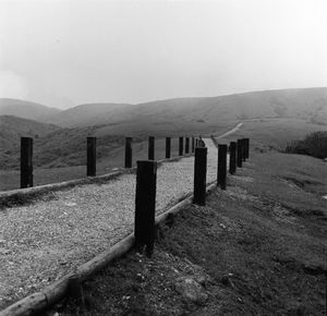 Wooden fence on field against sky