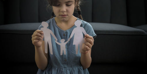 Portrait of young woman sitting on sofa at home