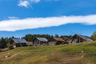 Houses on field against sky