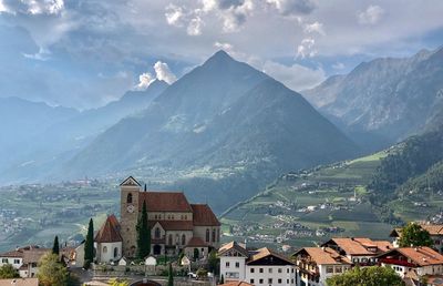 Aerial view of townscape and mountains against sky