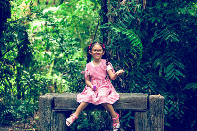 Portrait of a smiling girl sitting on plants