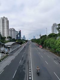 View of city street against cloudy sky
