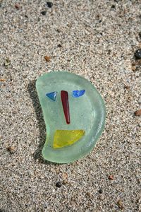 Close-up of arrow symbol on sandy beach