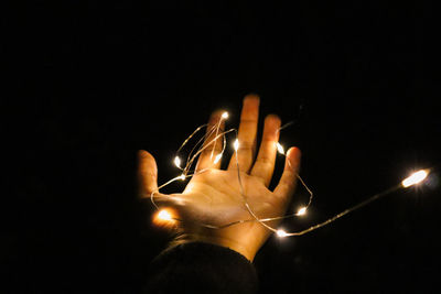 Close-up of illuminated hand over black background