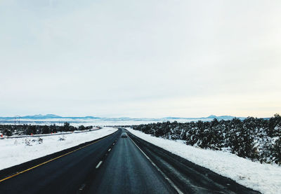 Snow covered road against sky