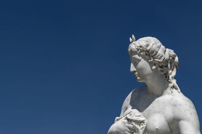 Low angle view of statue against clear blue sky